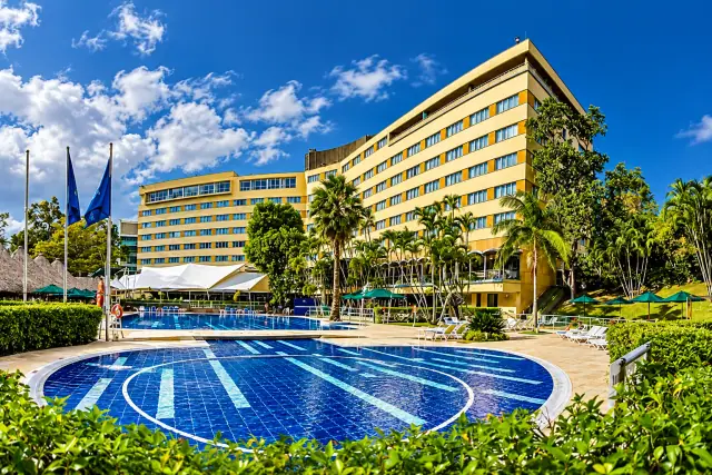 El InterContinental Medellín entre jardines tropicales y su piscina bajo el cielo azul
